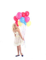 Fototapeta na wymiar Full length portrait of blonde girl wearing party dress, holding bunch of colourful balloons. Isolated on white studio background