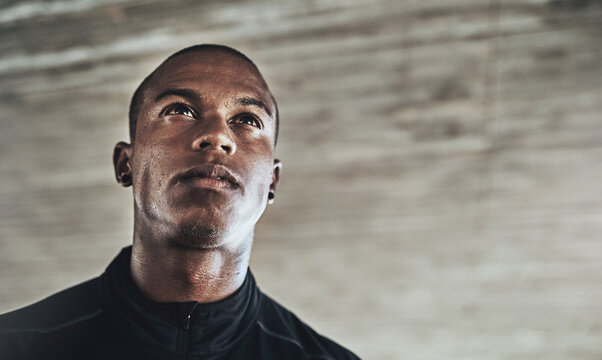 Fitness transforms the body along with the mind. Shot of a sporty young man exercising outdoors.