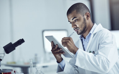Research plays a big role in solving problems. Shot of a scientist recording his findings on a...