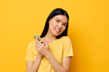 Portrait Asian beautiful young woman phone communication fun use yellow background unaltered