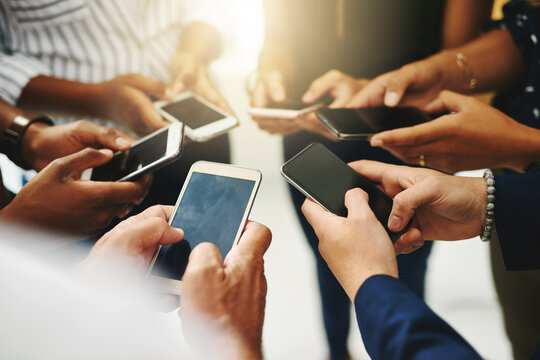 Theres No Faster Way To Spread The Word Than Online. Closeup Shot Of A Group Of Unrecognizable Businesspeople Using Their Cellphones In Synchronicity.