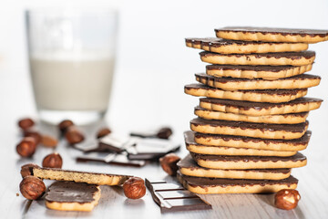 Homemade cookies with nuts, chocolate and milk on a wooden table and art background. Breakfast. Close.