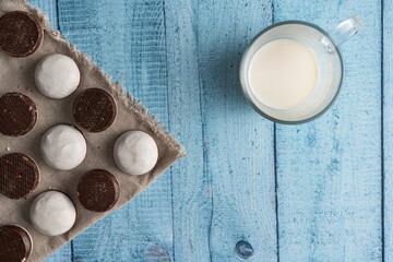 Homemade cookies with nuts, chocolate and milk on a wooden table and art background. Breakfast. Close.