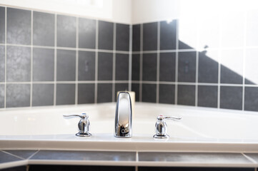 bathroom tub with black tile 