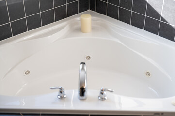 bathroom tub with black tile 