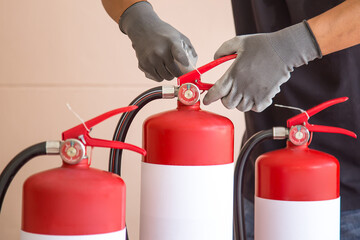 Close up fire extinguisher and firefighter pull safety pin on the handle for protection and prevent and safety rescue and use of equipment on fire training concept.