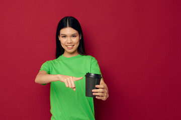 woman posing in a green t-shirt disposable black glasses red background unaltered