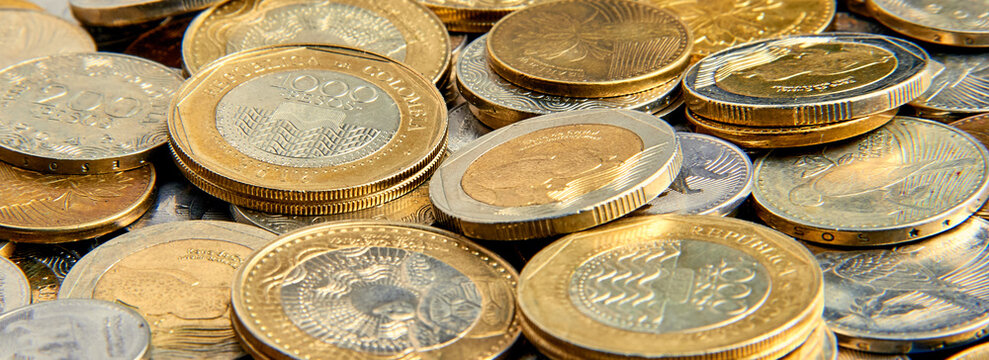 las monedas que a ahorrado  durante varios  d&iacute;as una madre esta en una mesa para ser contados y cambiados