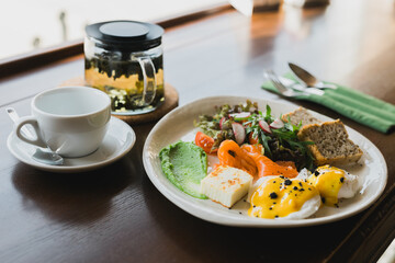 Delicious breakfast snack - salad with arugula and radish egg vegetables and grilled bread and slice of salmon