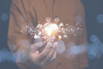 Businessman holding light bulb with network digital and business icon on hand. Creative new idea...