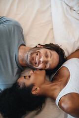 Youre the reason for my happiness. Cropped shot of a happy young couple lying in bed together. - obrazy, fototapety, plakaty