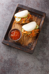 Pulled Pork and vegetables Steamed Bao Buns closeup in the board on the table. Vertical top view...