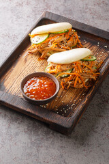 Pulled Pork and vegetables Steamed Bao Buns closeup in the board on the table. Vertical