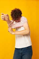cute red-haired guy putting on a striped t-shirt posing isolated background unaltered