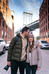 NEW YORK CITY PHOTOGRAPHER KISSING HER GIRLFRIEND AND ENJOYING AT DUMBO STREET WITH BROOKLYN BRIDGE...