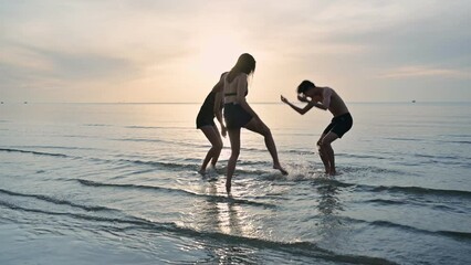 Group of young asian friends having fun hug the neck and splashing on the beach