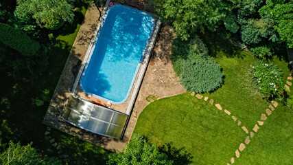 Swimming pool in beautiful garden aerial top view from above
