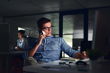 Determined to get the job done no matter what. Shot of a young businessman working late at night in a modern office.