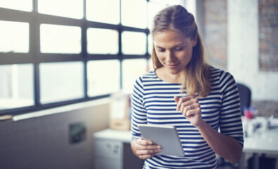 Tap into your creative self. Shot of a young designer using her digital tablet in her office.