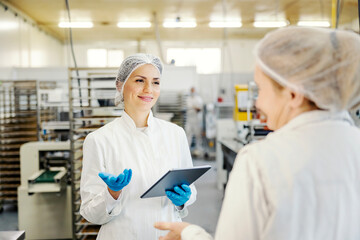 An inspector at bakery talking to an employee.