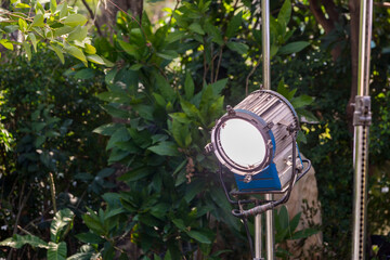 Naklejka premium Process of filming. Spotlight illuminates. Movie set with many lamps outdoor. Movie lights outdoor