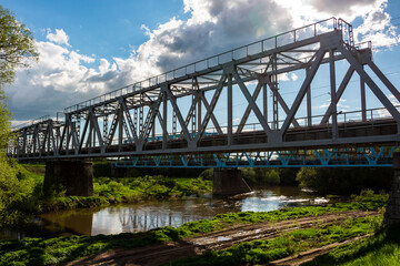 Fototapeta na wymiar Old metal structure of the railway bridge across the Protva river near the village of Obolenskoye, Kaluga region, Russia