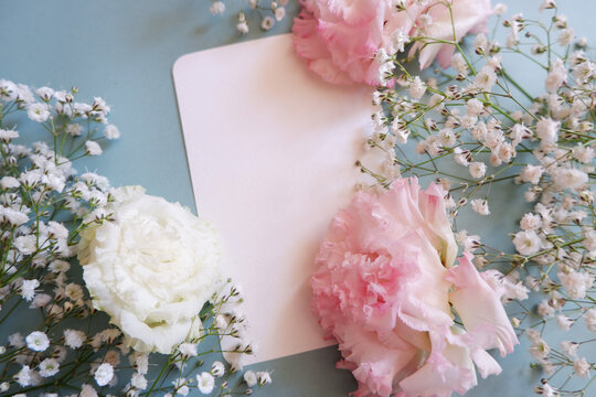 feminine wedding desktop with baby's breath Gypsophila flowers and pink flowers on pale green background. Empty space. Floral frame, web banner. Top view. Picture for blog or social media