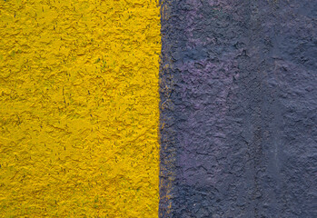 Fototapeta premium The surface is painted in half in yellow and black. Paint on a concrete wall. Texture of a colored surface. Black and yellow color. background image. Template for text. Two vertical halves.