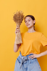 photo pretty girl fashion in yellow t-shirt dried flowers bouquet posing isolated background