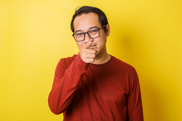 Fototapeta premium Casual man in glasses pointing at camera with index finger, accusing gesture isolated on yellow background