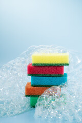multi-colored sponges for washing dishes in foam, the concept of cleanliness
