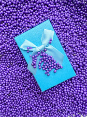 Blue gift box with ribbon and bow. Blue balls close up