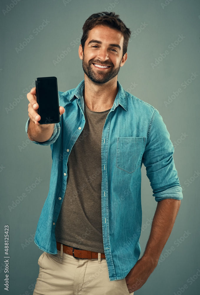 Poster take a look and tell me what you think. studio portrait of a handsome young man holding a cellphone 