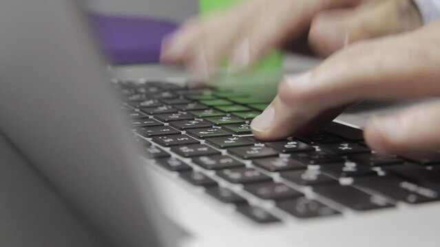 Hands are typing on a macbook keyboard