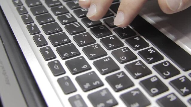 Hands are typing on a macbook keyboard