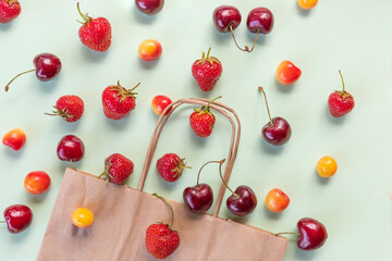 Naklejka na ściany i meble Organic fruits and vegetables with paper bag. view from above on a paper bag with fresh berries. Flat lay.Vegetarian and healthy food concept