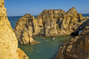 Panoramic view with Cliff, rocks and tourist boat on sea at Ponta da Piedade near Lagos, Algarve, Portugal