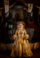 Medieval countess (baroness, princess, queen) sits on  throne in  crown in  ancient castle. Historical reconstruction, pretty woman in Saint Miklos castle in Ukraine