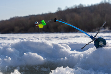 Fishing rod for winter fishing, river, snow and frost in Russia