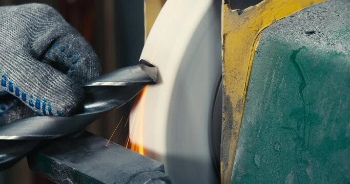 sharpen drill bits on a bench grinder, close up.