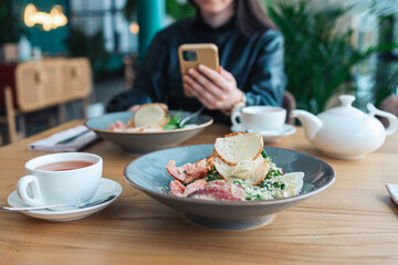 Girl in a cafe at lunch using the phone