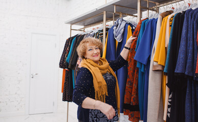 an adult woman chooses fashionable clothes in a clothing store.