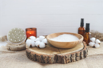 Organic spa beauty products and natural skin care concept. Set of natural oils, facial scrub, brush, candle and cotton on a wooden background