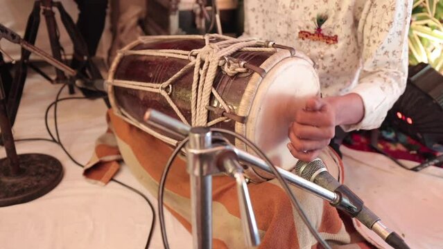 Shot of a man playing dholak at Indian Wedding Function at New Delhi, India

