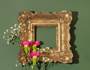 Spring creative layout with colorful flowers and retro style painting frame on bold green...