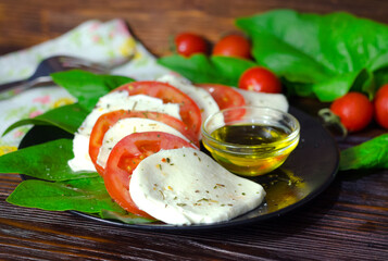 Salad of mozzarella, fresh tomatoes, spinach and basil.