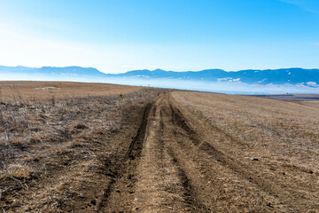 Dirt road leading on the top of the hill at late winter in the Carpathian mountains.