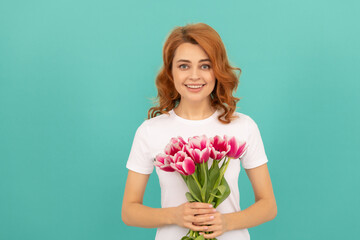 cheerful woman with tulip flower bouquet on blue background