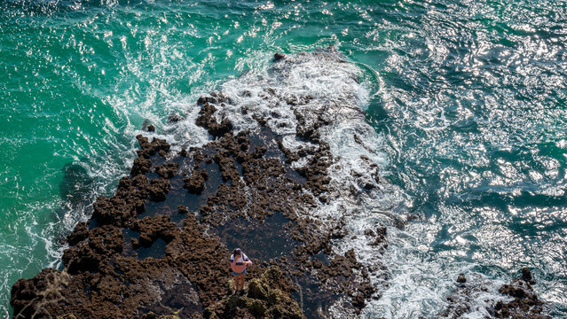 Turquoise seawater breaking against rocks 2