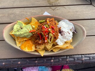 A close up view of sweet potatoes nachos with cream and guacamole 
